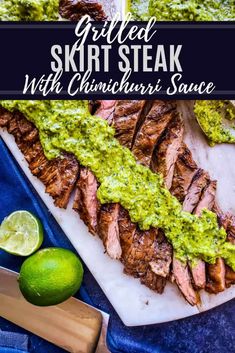 grilled steak with cilantro sauce on a cutting board next to limes