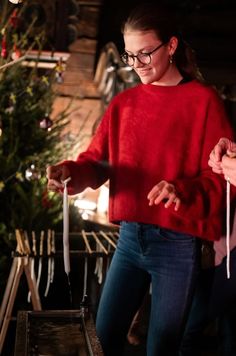 a woman in a red sweater is holding something