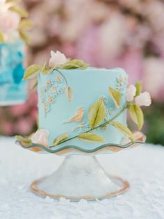 a blue cake sitting on top of a white table