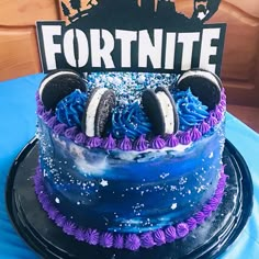 a blue cake with purple frosting and headphones on top that says fortnite