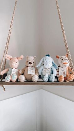 several stuffed animals are sitting on a rope shelf in a room with white walls and flooring