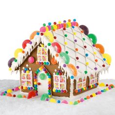 a gingerbread house with icing and sprinkles on it's roof