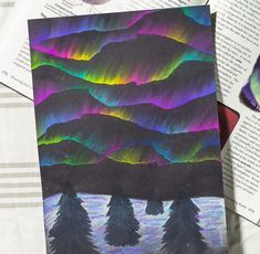 an image of aurora bores in the sky over mountains and trees on a sheet of paper