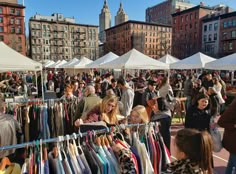 many people are shopping at an outdoor market