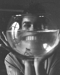 a man is looking through a fish bowl