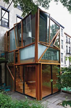 an unusual house built into the side of a building with lots of windows and stairs