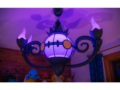 a purple chandelier hanging from the ceiling in a room with stuffed animals around it