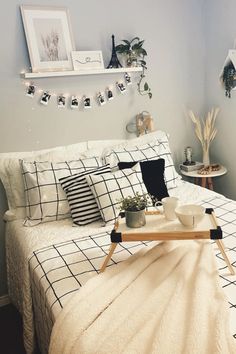 a bed with white sheets and black and white decor