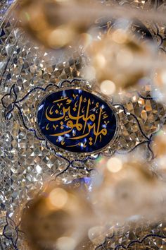 the arabic calligraphy is displayed in an intricately designed glass bowl with gold and blue accents