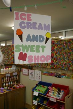 an ice cream and sweet shop sign hanging from the ceiling