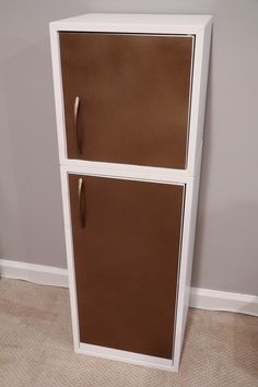 a white and brown refrigerator freezer sitting on top of a carpeted floor next to a wall