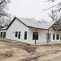 a large white building sitting on top of a dirt field