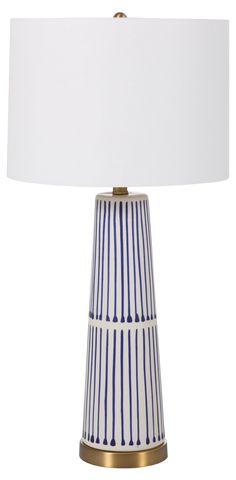 a blue and white striped lamp with a white shade on the top, against a white background