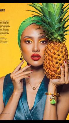 a woman holding a pineapple in front of her face and wearing bright yellow makeup