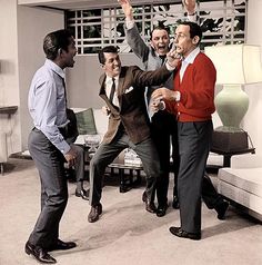 men in suits and ties are dancing with one another while the other holds his hand up