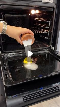 someone is cleaning an oven with a sponge