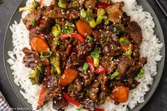 beef and broccoli stir fry over rice on a plate