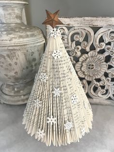 an origami christmas tree with snowflakes on it and a wooden star