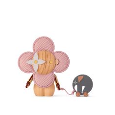 an elephant pulling a wooden toy with a flower on it's back and another animal standing next to it