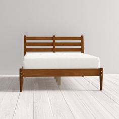 a wooden bed frame sitting on top of a hard wood floor next to a white wall