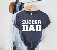 "Soccer Dad Shirt, Fathers Day Gift, Soccer Dad Gift, Soccer Lover Gift, Gift For Soccer Fan, Sport Shirt For Dad, Soccer Dad T shirt,Dad Tee   🎈HOW TO ORDER 1-) Please, check and review all the photos. 2-) Choose your t-shirt size and color. *Different styles of shirts may have different shades of same color choice due to different manufacturer brands. *For this reason, we recommend you to match shirts from the same styles if you want precisely matching colors (ex. Unisex, V-necks, Toddler, etc.). 3-) Click add to cart. You can go back to add more shirts. 4-)Click \"Proceed to check out\". 5-)When you check out, you can add a note to seller for any request. 🎈PRODUCT DESCRIPTION UNISEX SHIRTS * Unisex t shirt fits like a well-loved favorite, featuring a crew neck, short sleeves and desig Space Party Outfit, Soccer Dad Shirt, Bday Shirt, Space Tee, Funny Husband, Papa Shirts, Space Shirts, Soccer Fan, Husband Gifts