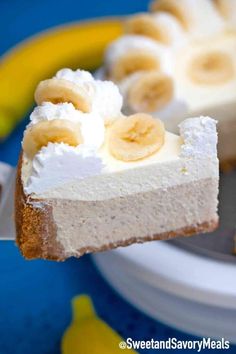 a piece of cheesecake with bananas on top is being held up by a fork