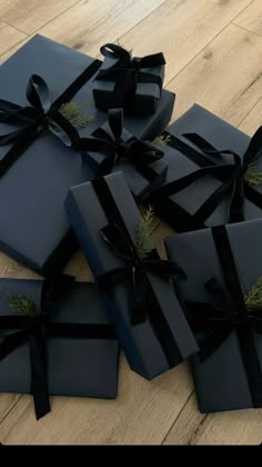 several black wrapped presents sitting on top of a wooden floor