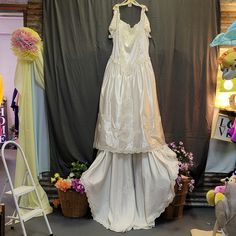 a wedding dress is displayed in front of a backdrop with teddy bears and other decorations