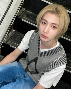 a young man sitting on the steps in front of an oven