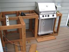 an outdoor kitchen built into the side of a house with wood pallets around it