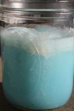 a jar filled with blue liquid sitting on top of a table