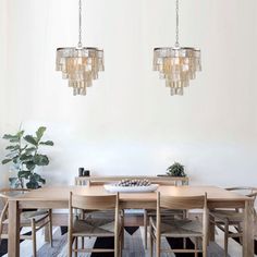 two chandeliers hanging from the ceiling above a dining room table