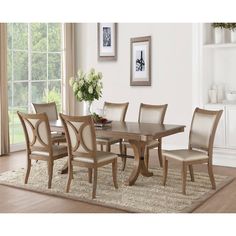 a dining room table with chairs and a rug