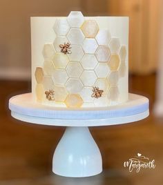 a white cake with honeycombs and bees on it