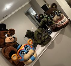 three stuffed animals sitting on top of a counter next to each other in front of a mirror