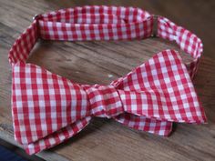 a red and white bow tie laying on top of a wooden table