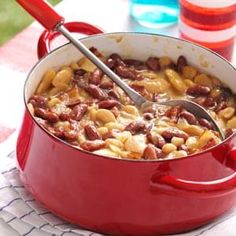 a red pot filled with beans on top of a table