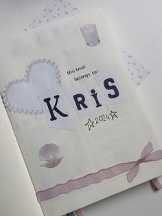 a book with the words kris written on it and a pink ribbon around the cover