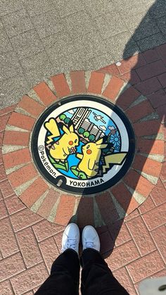 someone is standing on the ground with their feet up in front of a pokemon sign