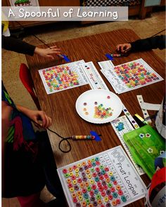 two children at a table with paper plates and pencils