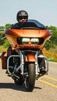 a man riding on the back of an orange motorcycle