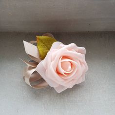 a pink rose is sitting on a silver surface