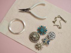 several different types of jewelry sitting on top of a piece of paper next to scissors