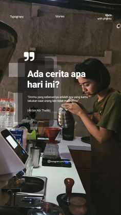 a woman standing in front of a counter using a cell phone and mixing something with a blender