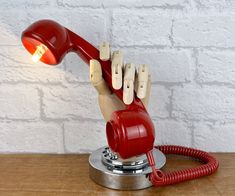 a red telephone sitting on top of a wooden table