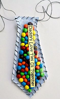 there is a tie made out of candy balls on the side of a white wall