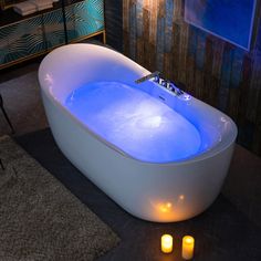 an illuminated bathtub with candles on the floor