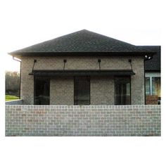 a brick house with a white fence around it and a clock on the side of the building