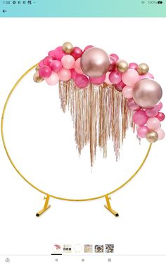 pink and gold balloon arch with tassels in the middle on a white background