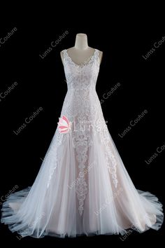 a white wedding dress on display in front of a black background